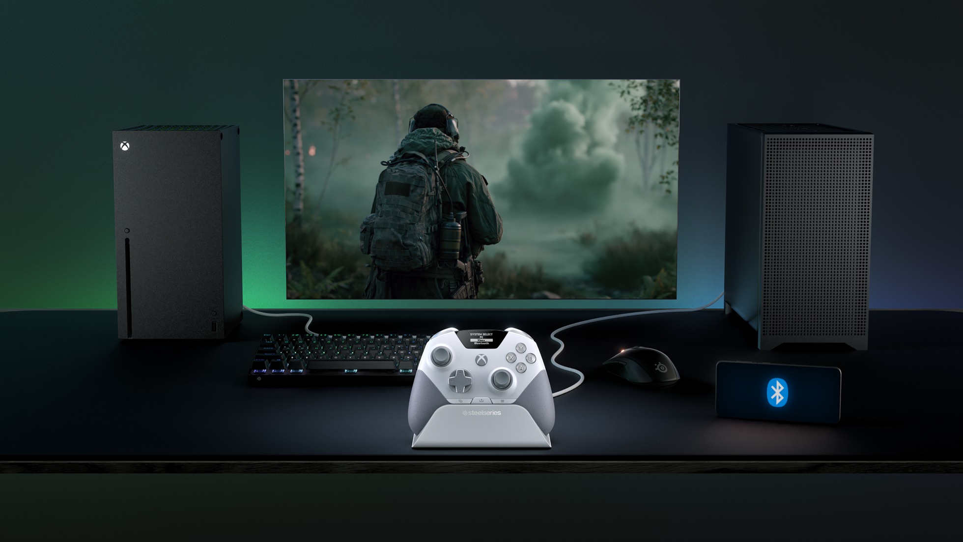 A gaming setup with an Xbox console, a monitor showing a soldier in a forest, a SteelSeries controller on a dock, keyboard, mouse, and Bluetooth icon.
