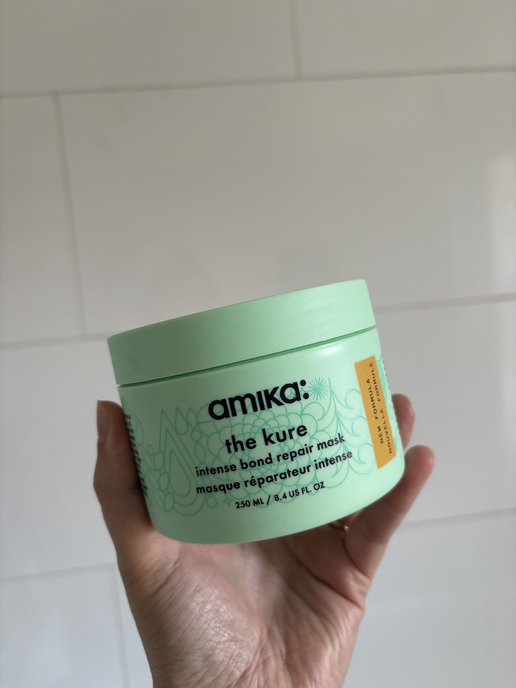 Mica Ricketts holding The Kure Intense Bond Repair Hair Mask