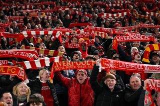 Fans hold scarves and sing before the English League Cup semi-final second leg football match between Liverpool and Tottenham Hotspur at Anfield in Liverpool, north west England on February 6, 2025.