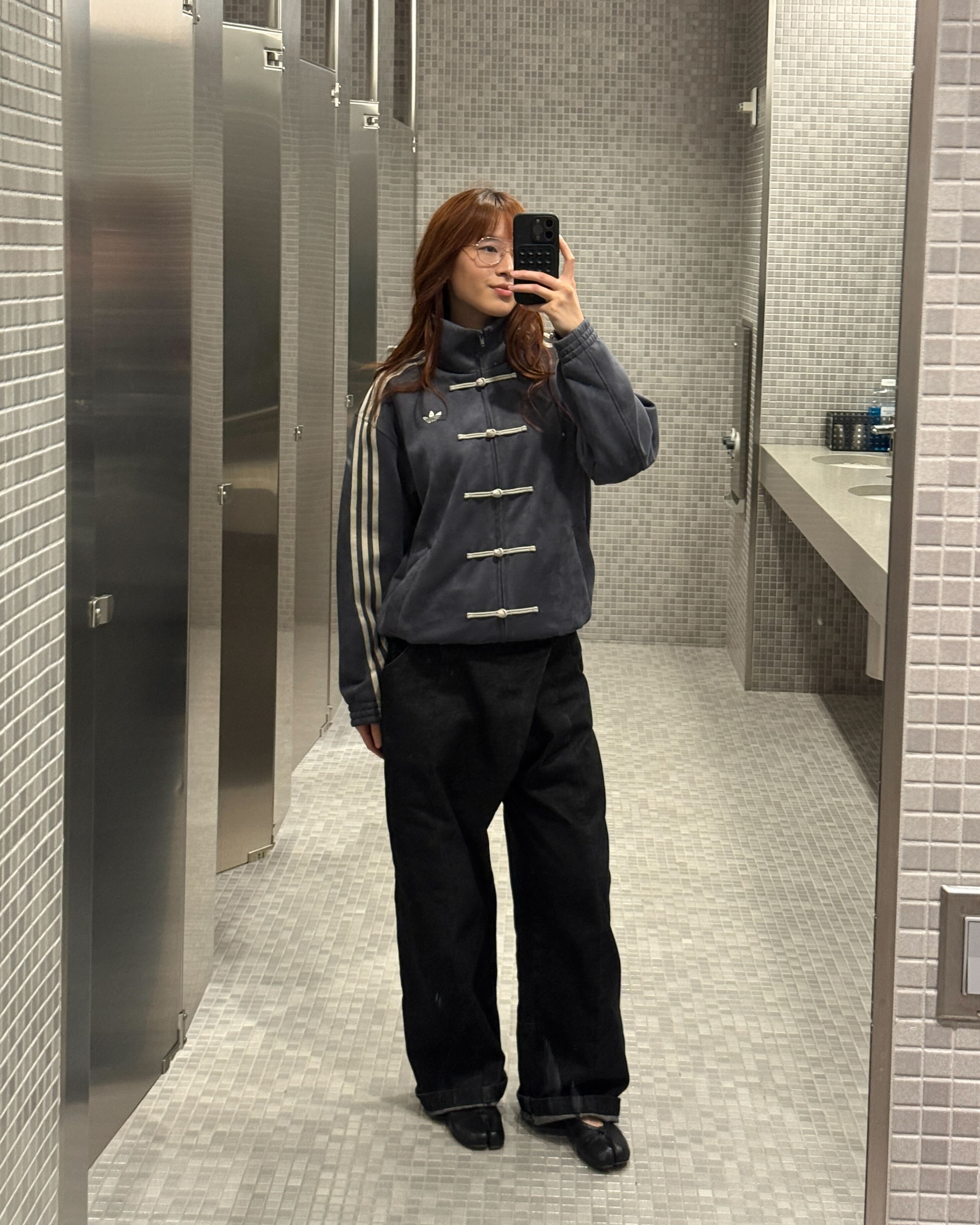 Kristina Ang at the office at her tech job wearing an Adidas track suit and wide-leg pants with Tabi shoes.