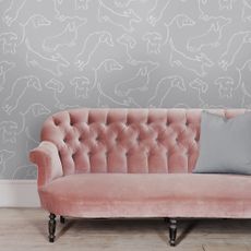 living room with grey dog designed wallpaper and pink sofa
