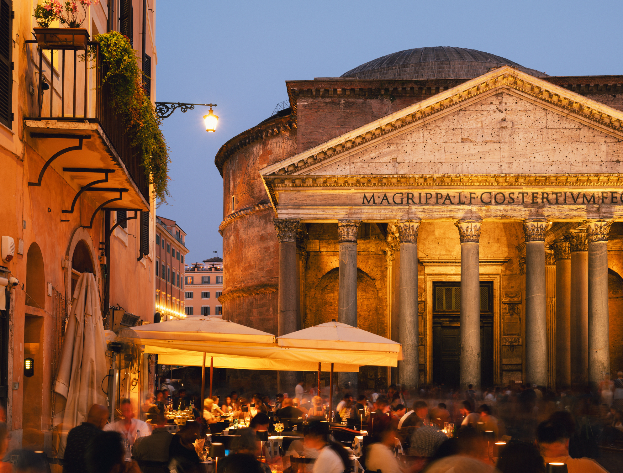 Italy, Lazio, Rome, People dining outside and walking in Piazza della Rotonda at dusk.