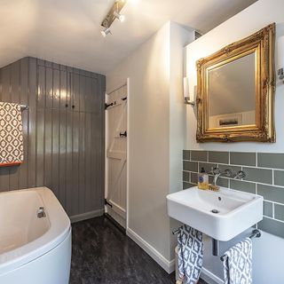 bathroom with white wall mirror on wall wash basin and grey flooring