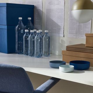 H&M home blue metal trinket bowls on sideboard next to water bottles 