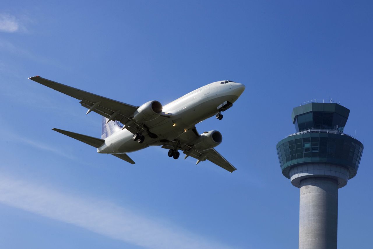 Plane flying past control tower 