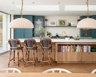 kitchen with dark blue green cabinets, island and patterned bar stools