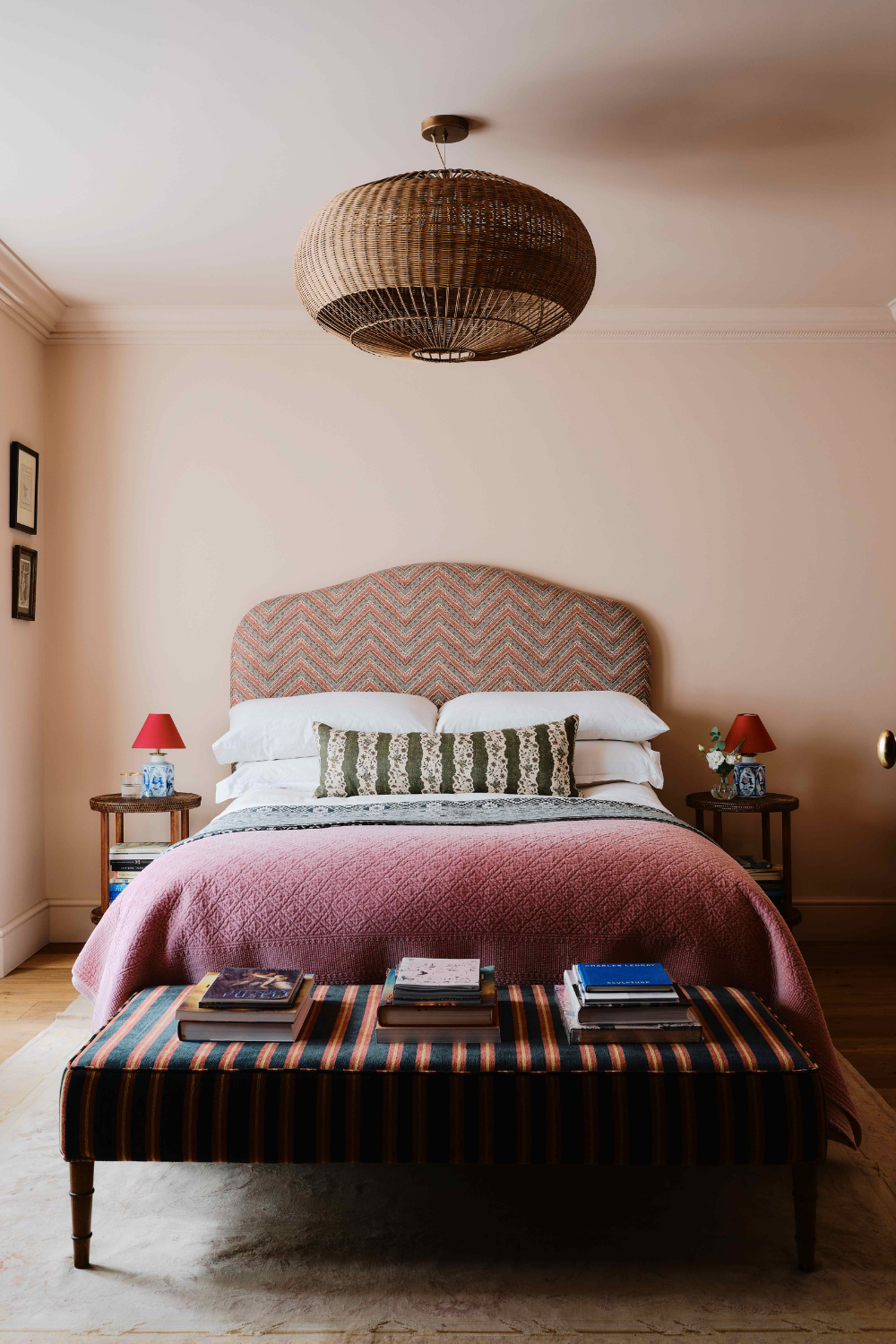 Pattern-filled bedroom featuring a striped bench, purple quilt, herringbone headboard, and two-tone bedside lamps