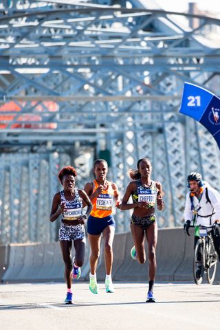 Peres Jepchirchir, Viola Cheptoo and Ababel Yeshaneh lead the pack of the women's race through the east side of Manhattan over the Madison Avenue Bridge during the 2021 TCS New York City Marathon