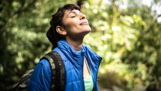 woman breathing fresh air in a forest