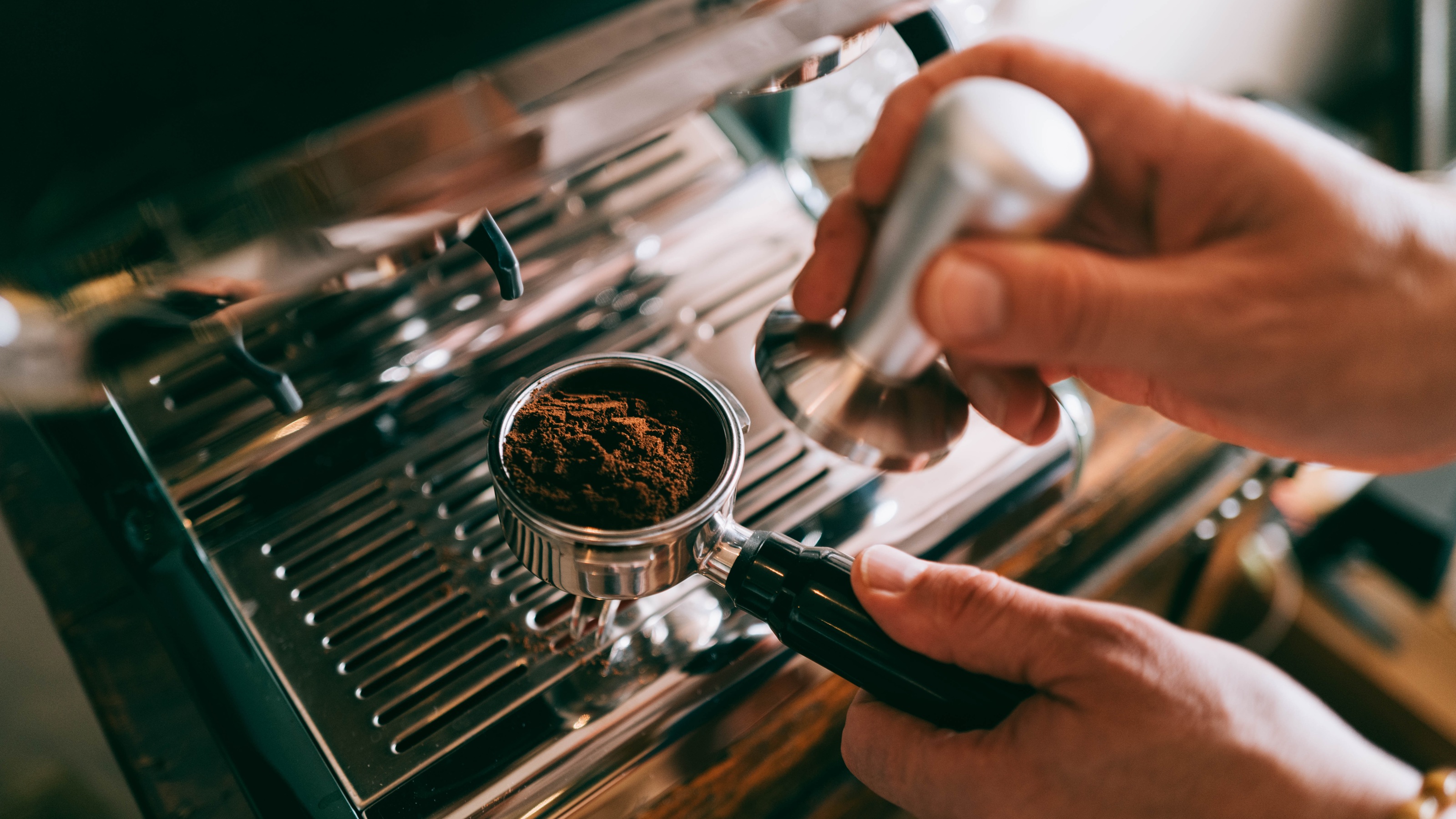 A man's hands making espresso.
