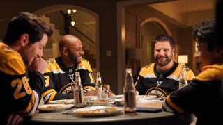 Romany Malco and James Roday Rodriguez sit at a table in Bruins uniforms in A Million Little Things