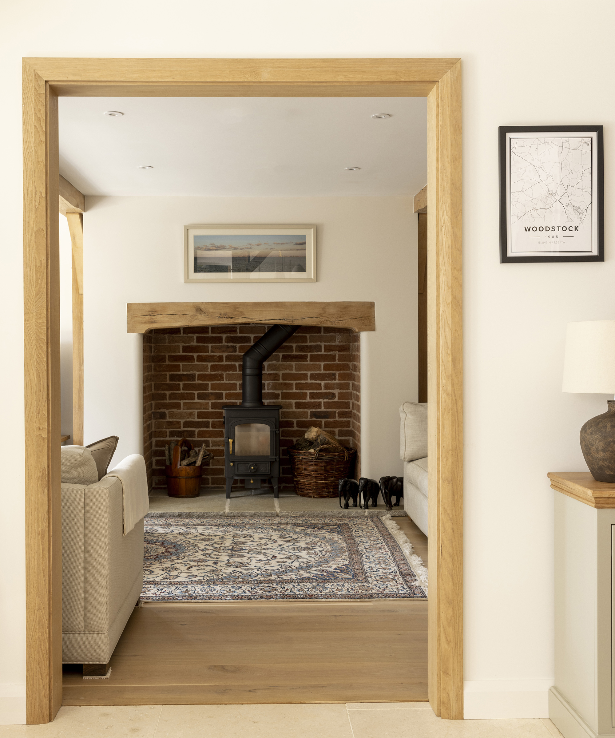 A cosy living room with a log burning stove set into a recessed fireplace