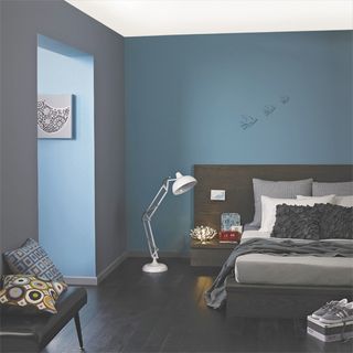 bedroom with muted blue wall and wooden floor