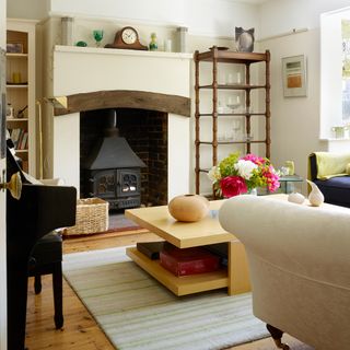 Neutral living room with wood burner in brick lined fireplace