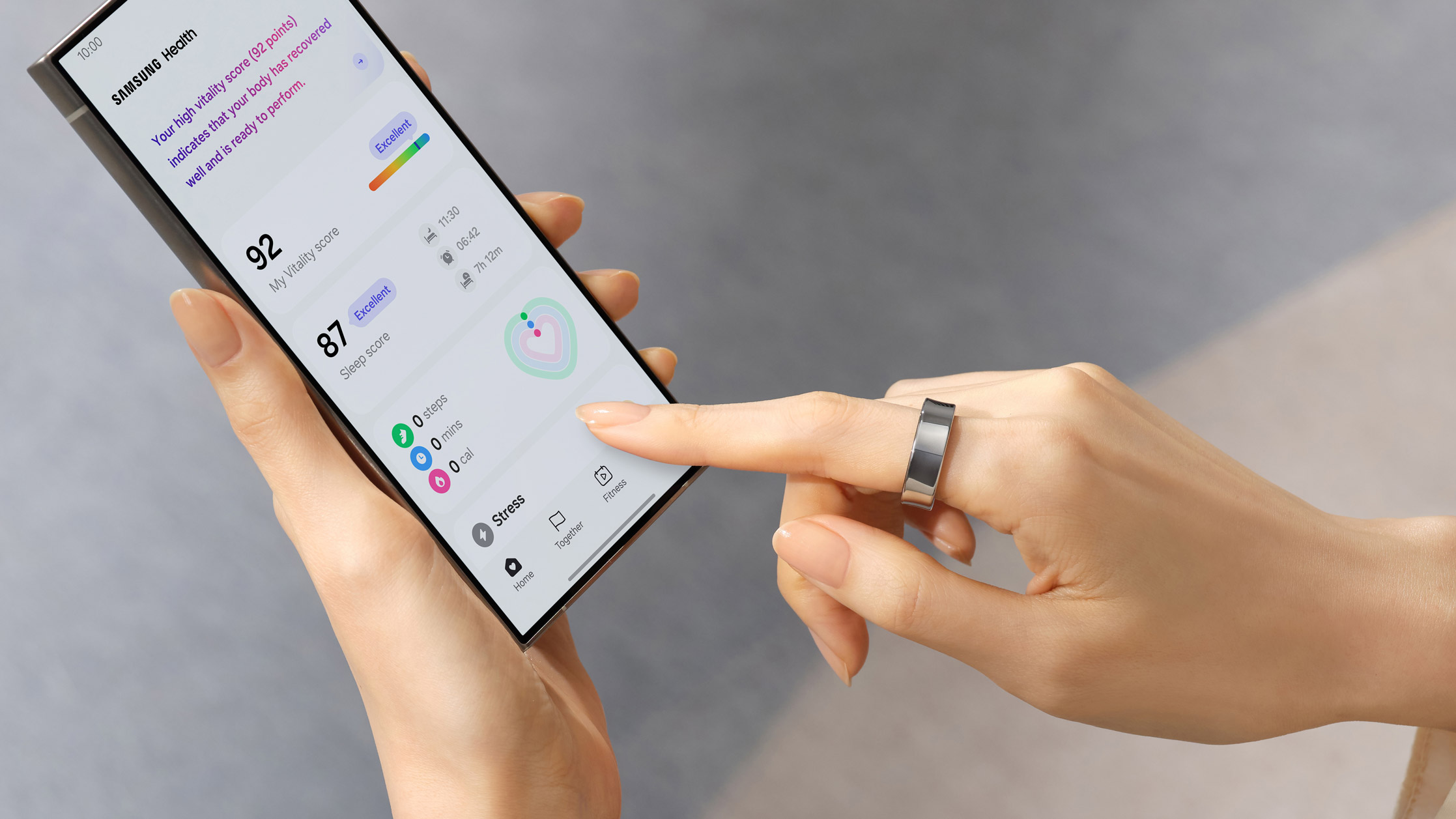 En kvinne berører en mobiltelefon med en Samsung Galaxy-ring rundt fingeren.