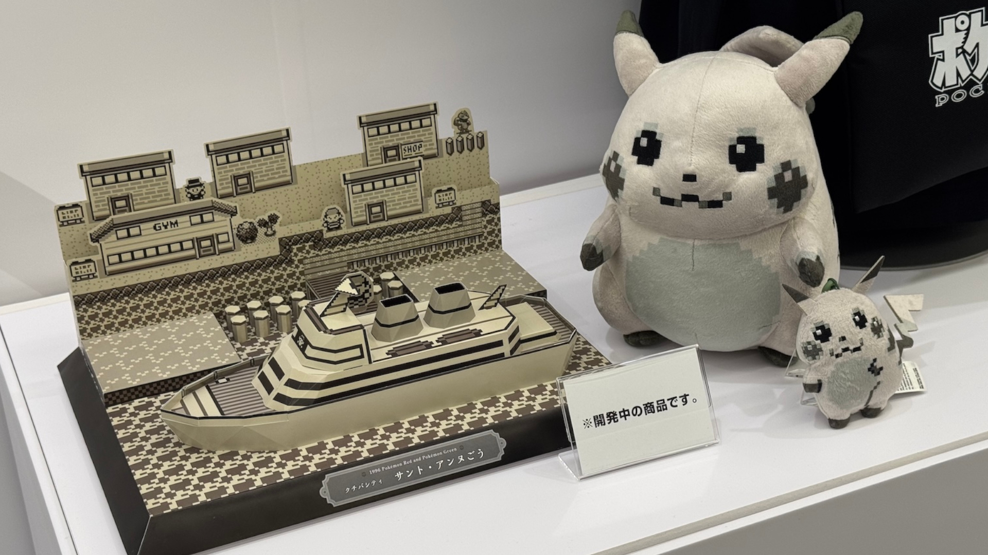 Pixel Pikachu plushie alongside a Pokemon diorama based on Pokemon Red and Green from 1996