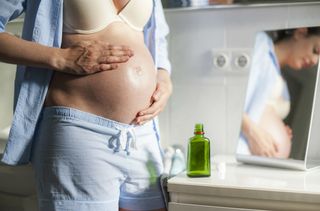 How to cool down when pregnant illustrated by pregnant woman in vest top