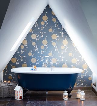 bathroom with triangular wallpaper with lights blue bathtub and white designed candle lanterns