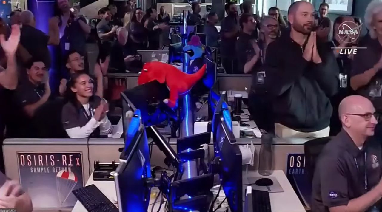 people clapping and cheering a spacecraft's return to Earth with asteroid samples