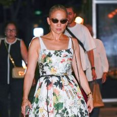 Jennifer Lopez walks in New York City wearing a watercolor floral dress with a pair of slingback heels in a celebrity trend
