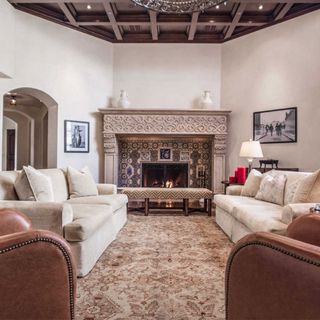living room with limestone fireplace and ceiling beams