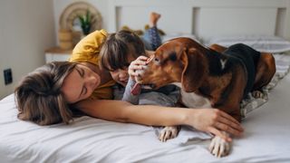 Family laying on a bed with their dog