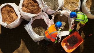 Workmen with bags of sand