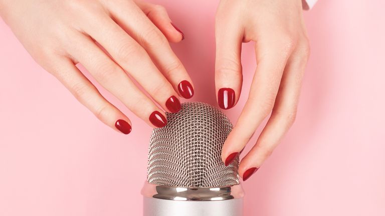 Se and ASMR: Woman hand with perfect manicure gently touching the microphone. She is about to do nail tapping. Making ASMR sounds. Triggers for relaxation, good sleep and stress relief.