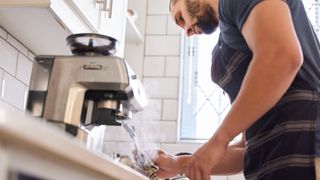 Man purging steam wand of coffee machine