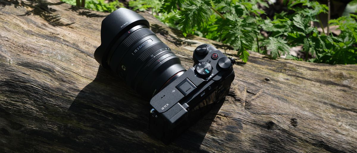 Sony A7CR camera with a lens attached sat on a wooden log