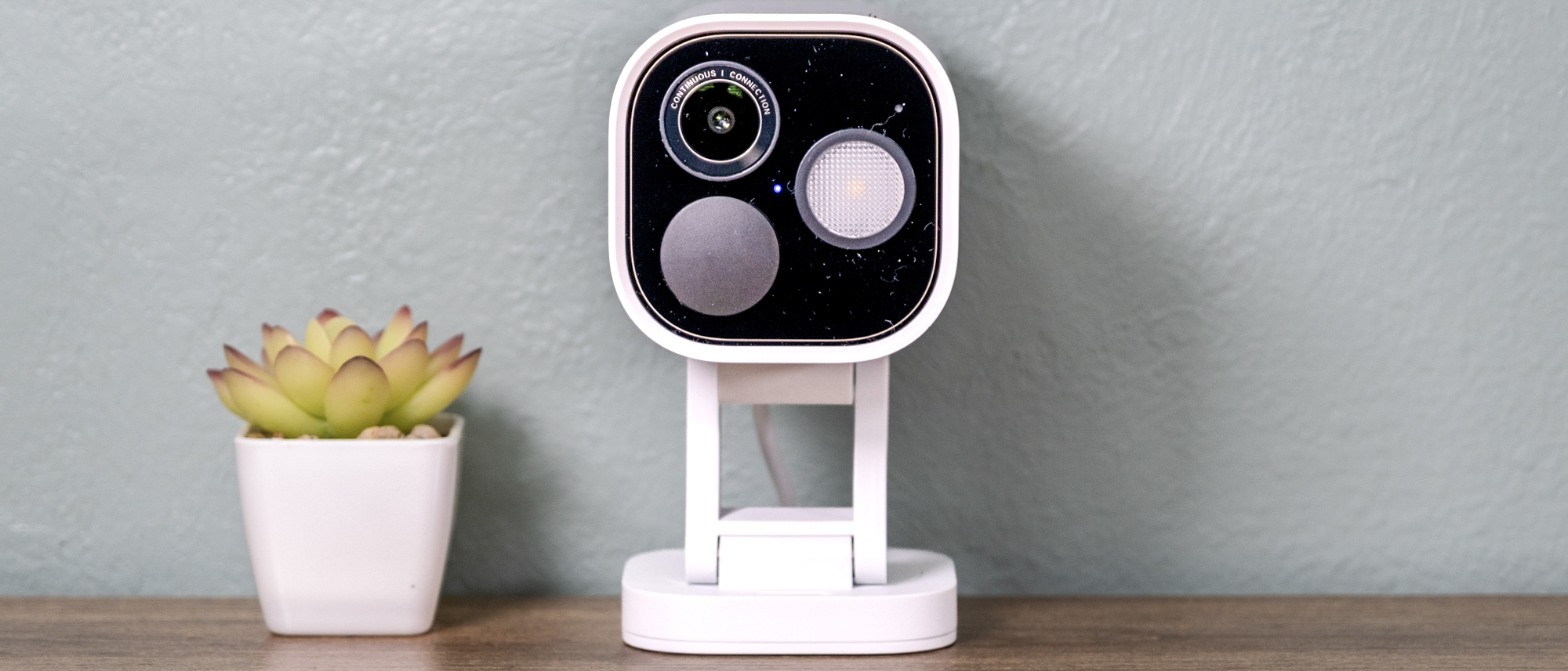 Aqara Camera Hub G5 Pro on a shelf with a small cactus.