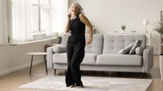 Woman dancing in living room in front of sofa to get 10,000 steps in without leaving the house