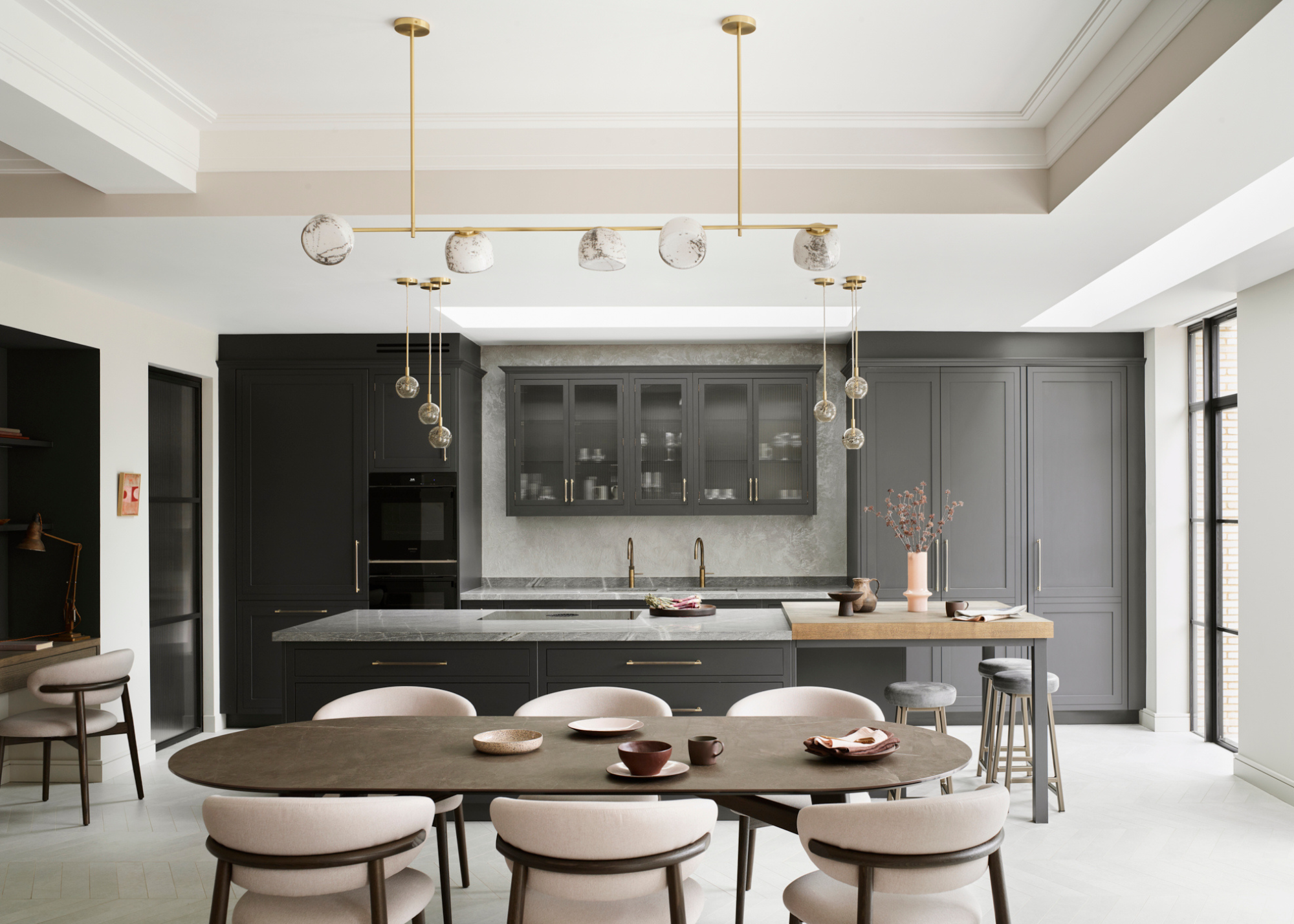 A sleek modern kitchen in charcoal and off whites, with bith floor ot ceiling cabinetry and floating upper cabinets