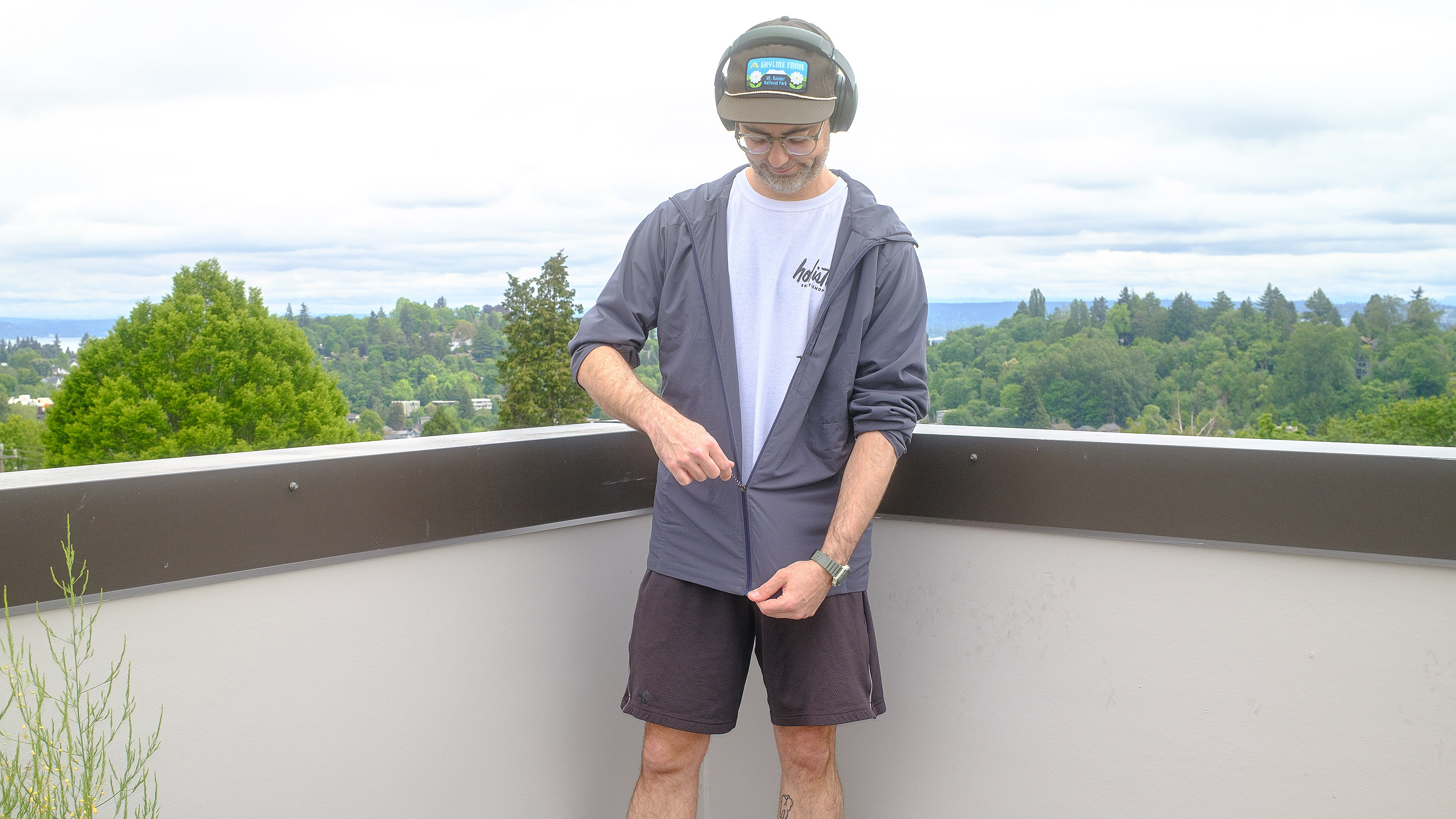 Senior writer Dan Bracaglia wearing the Patagonia Nano-Air Ultralight in grey/blue on the roof of his home in Seattle, Washington with trees and overcast skies in the distance