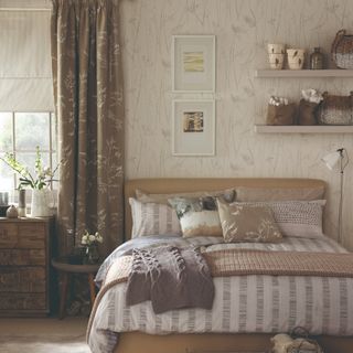 A bedroom with a floral wallpaper and matching curtains