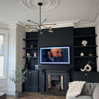 living room with black walls and period details such as a ceiling rose and ornate fireplace