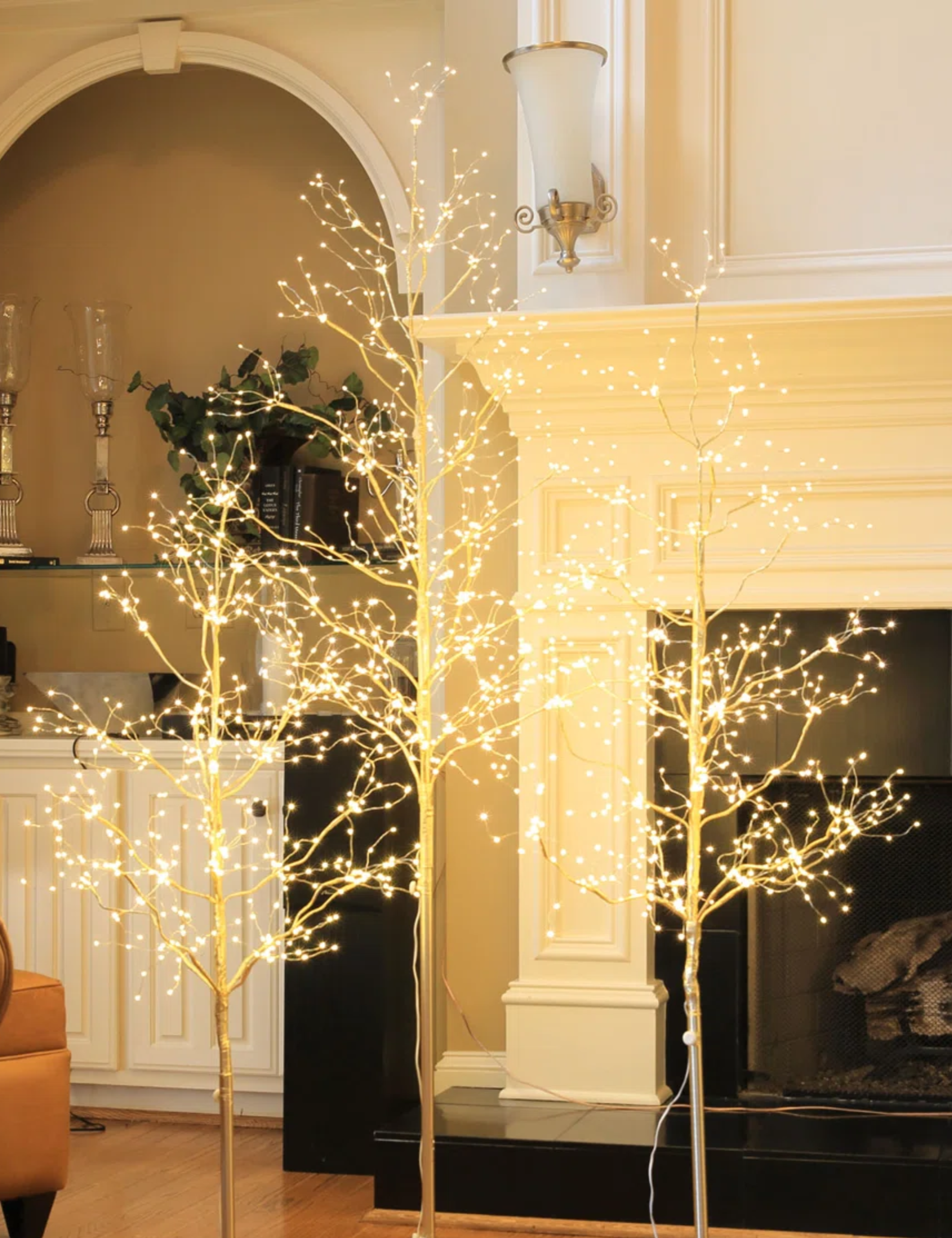 Tree of twinkling twig Christmas trees clustered in a cozy living room