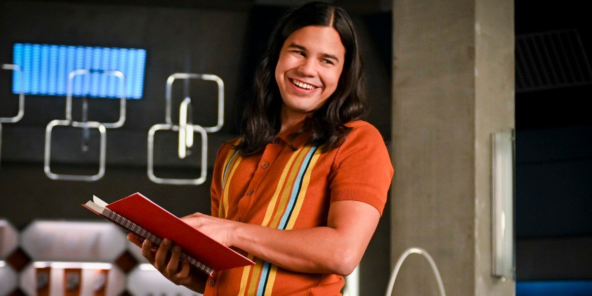 Cisco smiling while holding a book The Flash CW