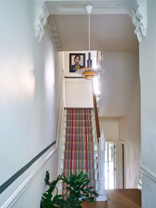 Light entryway with brightly colored runner up staircase.