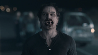 A still from the movie Fright Night of a vampire holding its bloody mouth wide open.