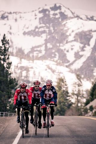 RadioShack riders ride through the snowy mountain scenery.