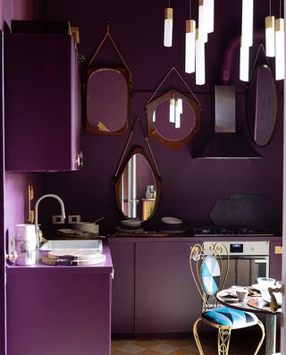 Purple kitchen interior and mirrors hung on wall