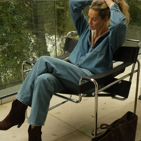 Influencer @anoukyve wears a denim shirt with blue jeans and suede heeled boots.