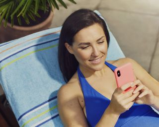 Woman on sun lounger checking phone
