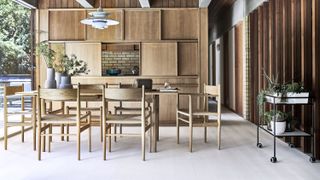A kitchen diner with sliding door storage in beech wood with beech wood dining table in a modern home with laminate flooring