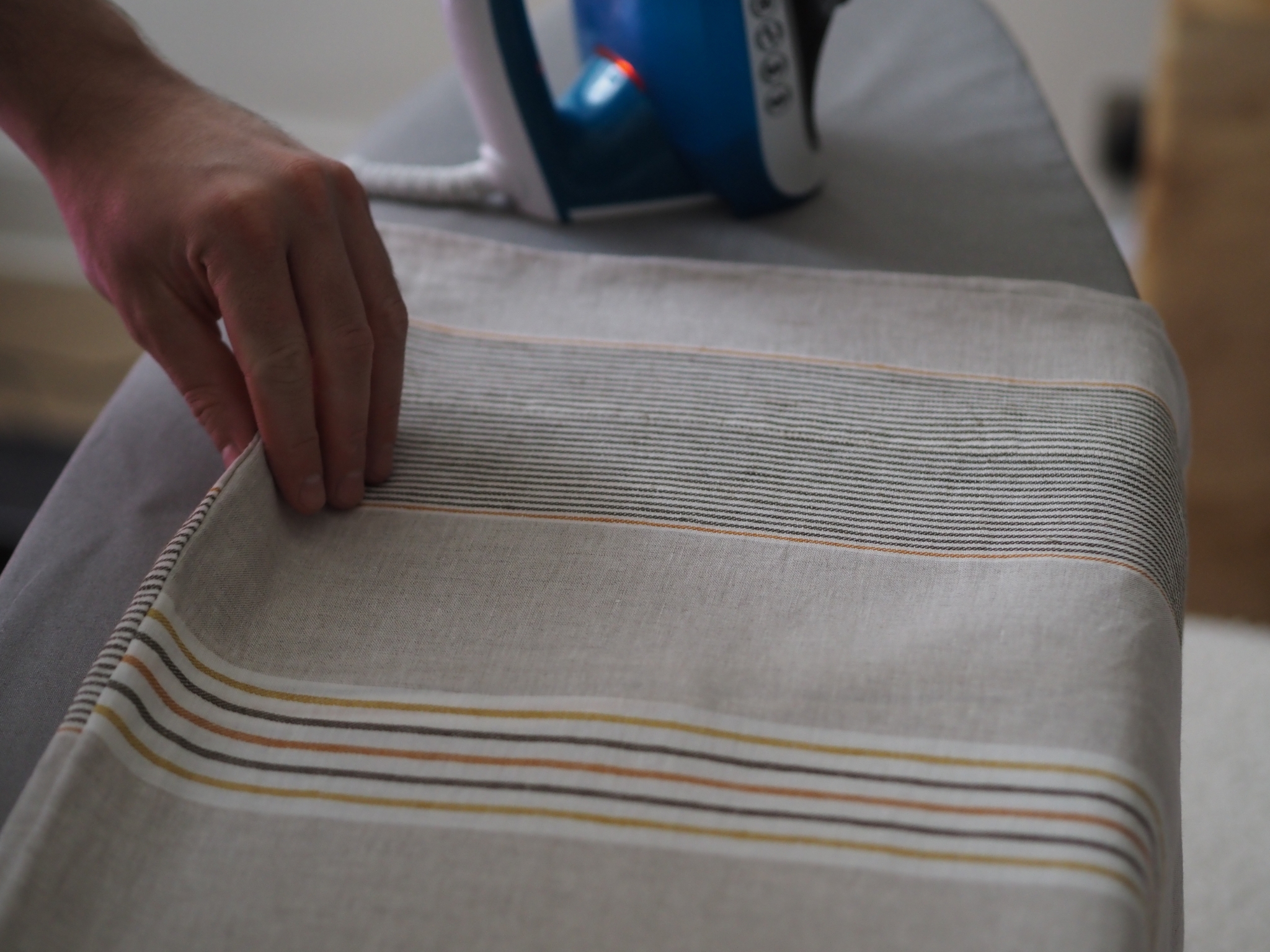 striped linen bedding being ironed