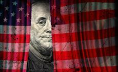 An American flag used as a curtain is parted, showing an image of Benjamin Franklin from the $100 bill.