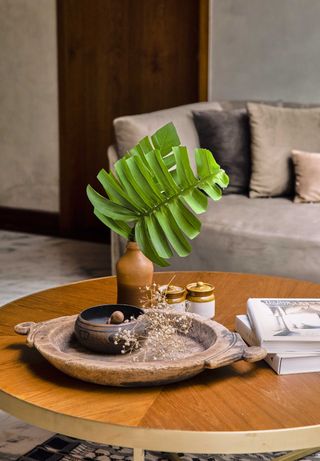 A living room coffee table with a round tray