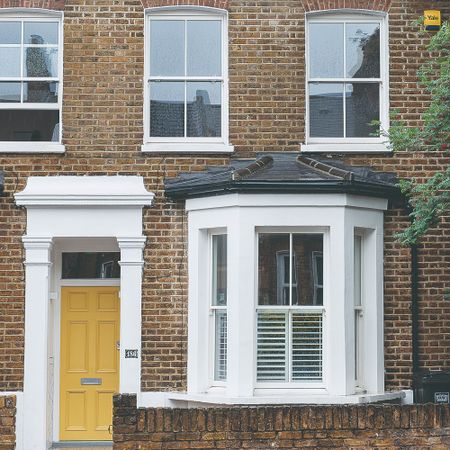 Front of a brick house with yellow front door