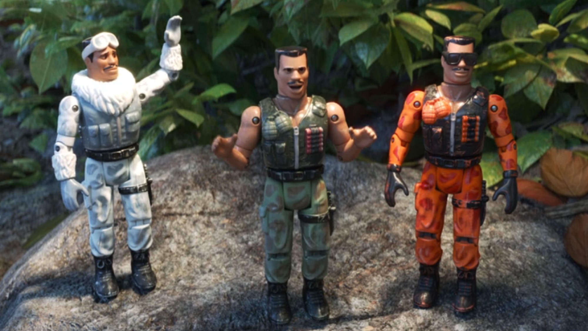 From left to right: Three Combat Carls standing next to each other. One is trying to give a high five, one is talking and the other is looking forward.